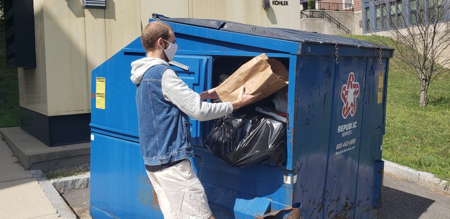 FSU student Peter Wade tries to fit his trash into a full dumpster